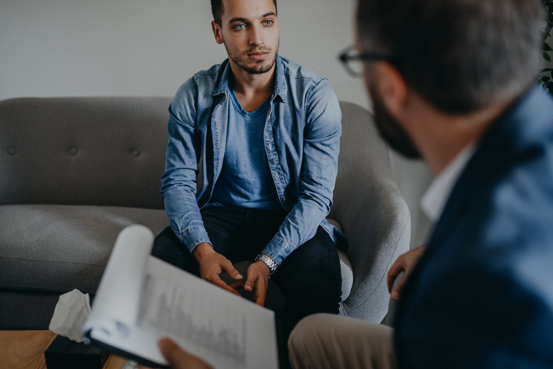 Man taking notes while talking with younger man